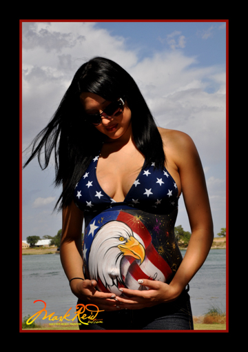 dark haired woman holding her pregnant belly with a painting of an eagle